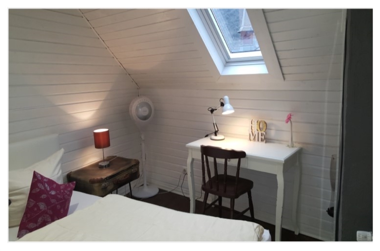 Schlafzimmer mit Doppelbett und Tisch